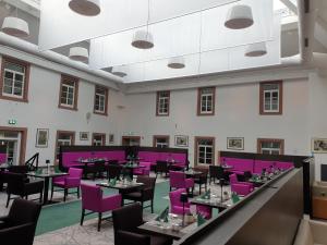 a dining room with purple chairs and tables at Augustiner Hotel in Hillesheim