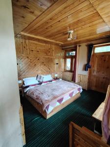 a bedroom with a large bed in a wooden room at Ananta Valley Home's in Kulu +9 photos