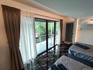 a bedroom with a bed and a large window at 19 Farmstay in Bukit Mertajam