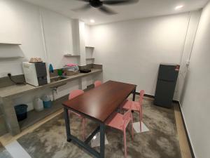 a dining room with a table and pink chairs at 19 Farmstay in Bukit Mertajam +24 photos