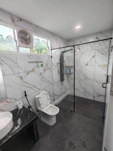 a bathroom with a shower and a toilet and a sink at 19 Farmstay in Bukit Mertajam