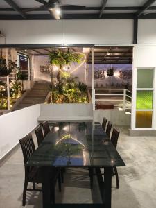 a black table and chairs in a room with plants at 19 Farmstay in Bukit Mertajam