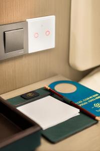 a desk with a book and a pen on it at NOOMA Hotel Aitmatova in Bishkek