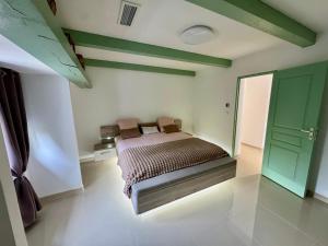 a bedroom with a bed and a green door at Maison en campagne in Salon-de-Provence