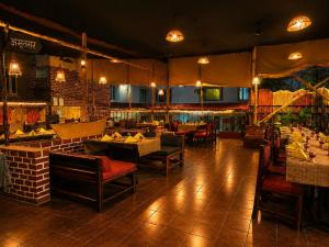 a restaurant with tables and chairs in a room at Pride Premier Pune in Pune
