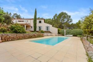 a swimming pool in front of a house at Chambres D’hôte Cotignac in Cotignac