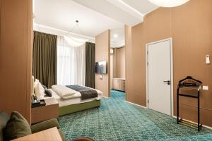 a hotel room with a bed and a door at NOOMA Hotel Aitmatova in Bishkek