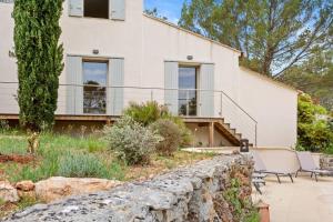 a house with a stone wall and a patio at Chambres D’hôte Cotignac in Cotignac