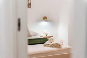 a room with a bed and towels on a shelf at Il Cortile Holiday House in Caccamo +59 photos
