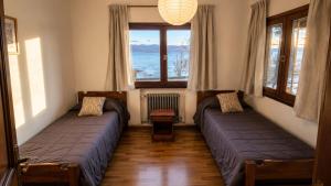 two beds in a room with a window at Centrally located lakefront house in San Carlos de Bariloche