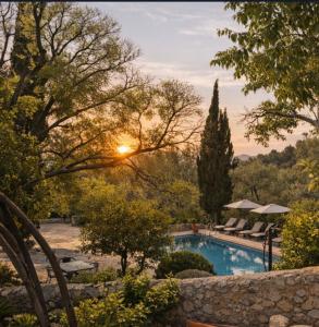 a pool in a garden with the sunset in the background at Agroturismo Son Penyaflor in Alaró