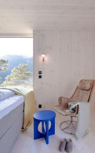a bedroom with a bed and a chair and a window at Bratt bolig in Åndalsnes