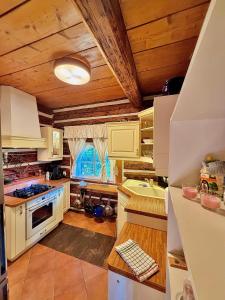 a kitchen with white cabinets and a wooden ceiling at Wellness Roubenka u Obory in Svratouch