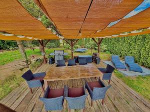 a wooden table and chairs under a wooden umbrella at Wellness Roubenka u Obory in Svratouch