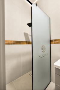 a glass door in a bathroom with a novation sign at NOOMA Hotel Aitmatova in Bishkek