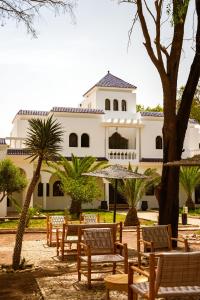 a building with chairs and trees in front of it at Maison d'hôtes Villa Latifa Essaouira in Essaouira