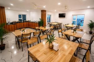 an empty restaurant with wooden tables and chairs at Keerthis Grand Hotel near Kempegowda International Airport in Bangalore
