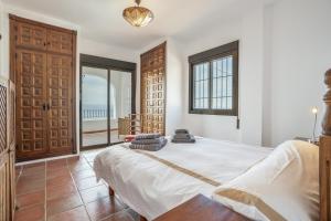 a bedroom with a large bed and a balcony at Villa Quietud in Salobreña +28 photos