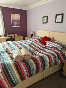 a bedroom with a bed with two towels on it at Maple House Apartment in Kelso