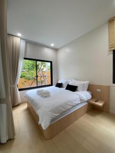 a bedroom with a large bed with a window at The Town Pool Villas in Krabi +90 photos