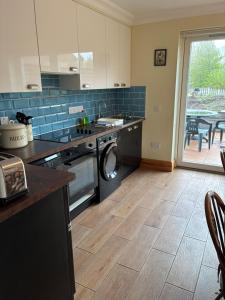 a kitchen with a washer and a sink and a dishwasher at Maple House Apartment in Kelso