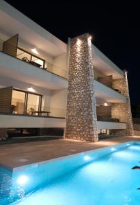 a villa with a swimming pool at night at Almondo Suites in Amigdhaleón