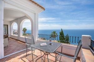 a balcony with a table and chairs and the ocean at Villa Quietud in Salobreña