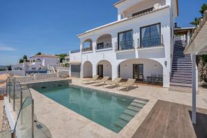 a villa with a swimming pool and a house at Villa Quietud in Salobreña