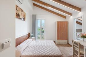 a white bedroom with a bed and a desk at Villa Degli Dei in Agerola +94 photos