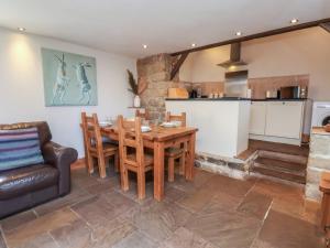 a kitchen and living room with a wooden table and chairs at Horseshoe Cottage in Middlesbrough