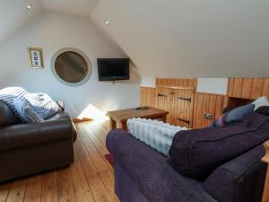 a living room with two couches and a tv at Horseshoe Cottage in Middlesbrough