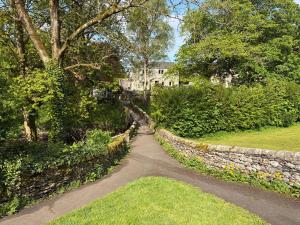 a walkway through a garden with a stone wall at Cross Winds in Lancaster