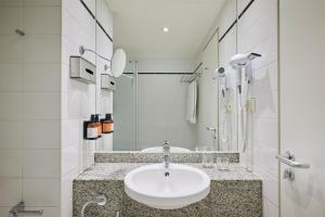 a white bathroom with a sink and a shower at iStay by NH Berlin City Ost Hotel in Berlin