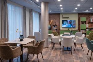 a waiting room with tables and chairs and a tv at DOMITYS - Les Canotiers in Argenteuil