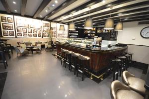 a restaurant with a bar and chairs and a clock at Sercotel Hotel Parque in Las Palmas de Gran Canaria