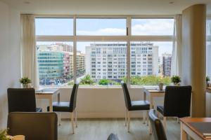 a restaurant with tables and chairs and a large window at Sercotel Hotel Parque in Las Palmas de Gran Canaria