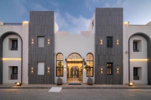 a large white building with a large door at Santino Boutique Hotel in El Alamein
