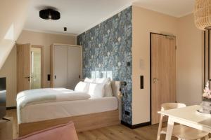 a bedroom with a large bed with a blue wall at Gezeiten Suites Büsum - Neueröffnung in Büsum
