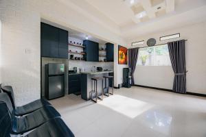 a kitchen with dark blue cabinets and a counter at The Lavana Signature Villa Alessa Puncak in Puncak