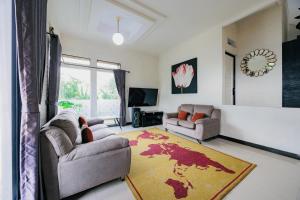 a living room with two couches and a rug at The Lavana Signature Villa Alessa Puncak in Puncak