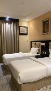 a hotel room with two beds and a window at مشارف الفخامة أبها - Masharef AlFakhama ABHA in Abha