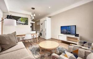 a living room with a couch and a table at Cosy Regency menylin apartment in Pretoria
