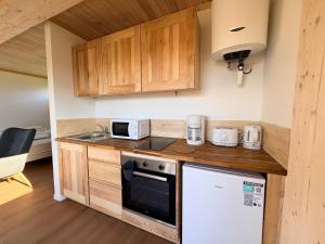 a kitchen with wooden cabinets and a stove top oven at Les Gîtes du Chênelet in Landrethun-le-Nord