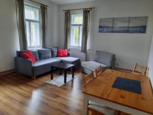 a living room with a couch and a table at Apartmány Janská in Janská
