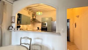 a kitchen with green cabinets and a table and a mirror at Logis de la Rue des Arts Centre historique 5 pers - Classé 3 étoiles in Blois