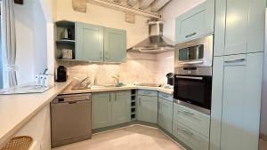 a kitchen with green cabinets and a stove top oven at Logis de la Rue des Arts Centre historique 5 pers - Classé 3 étoiles in Blois +7 photos