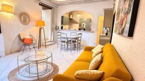 a living room with a yellow couch and a kitchen at Logis de la Rue des Arts Centre historique 5 pers - Classé 3 étoiles in Blois