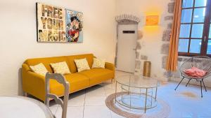 a living room with a yellow couch and a glass table at Logis de la Rue des Arts Centre historique 5 pers - Classé 3 étoiles in Blois
