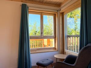 a room with two windows and a table and chairs at Les Gîtes du Chênelet in Landrethun-le-Nord