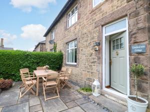 a patio with a table and chairs in front of a building at Lumford Mill Cottage in Bakewell